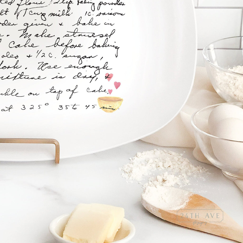 Detail view of handwritten family recipe printed on white serving platter with small heart bowl illustration.